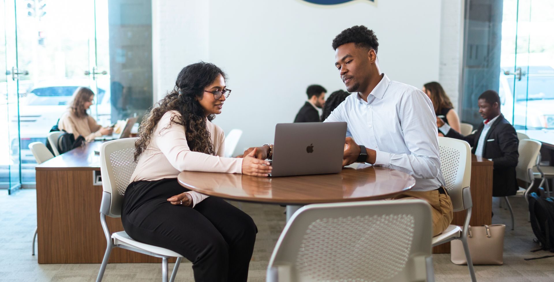 students discussing their work at a table